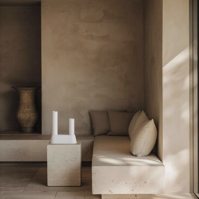 Geometric plaster artifact arranged on a monolithic stone bench next to a neutral sofa, serving as a premium design gift idea and fine art accessory for residential interior styling portfolios.